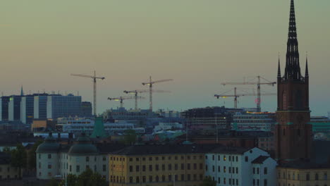 aerial sunset shot of riddarholm church with construction cranes in background