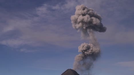 放大火山的镜头,火山在慢动作中吐出烟雾