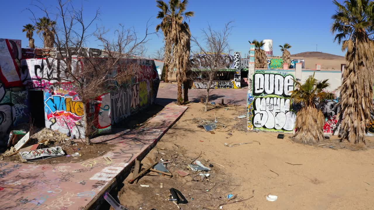 Aerial between two dilapidated buildings with graffiti on them