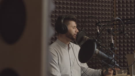 young bearded man talks about an interesting subject in a radio recording studio