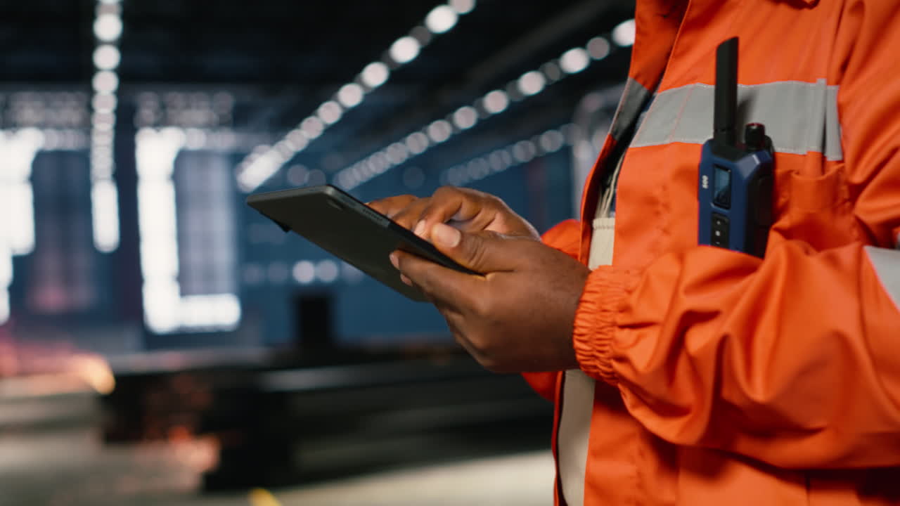 Black male technician in a warehouse inspecting metal automation tools