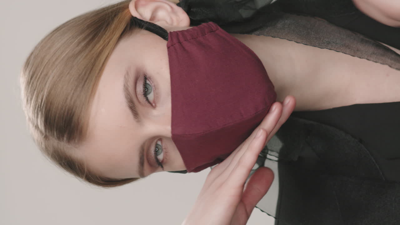 세련된 얼굴 마스크를 입은 우아한 여성의 수직 초상화