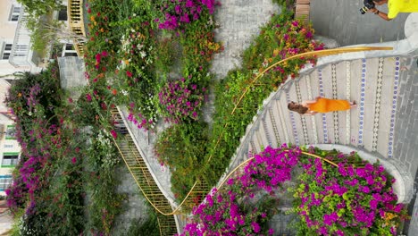aerial establishing shot of a model with photographers at the dragon stairs