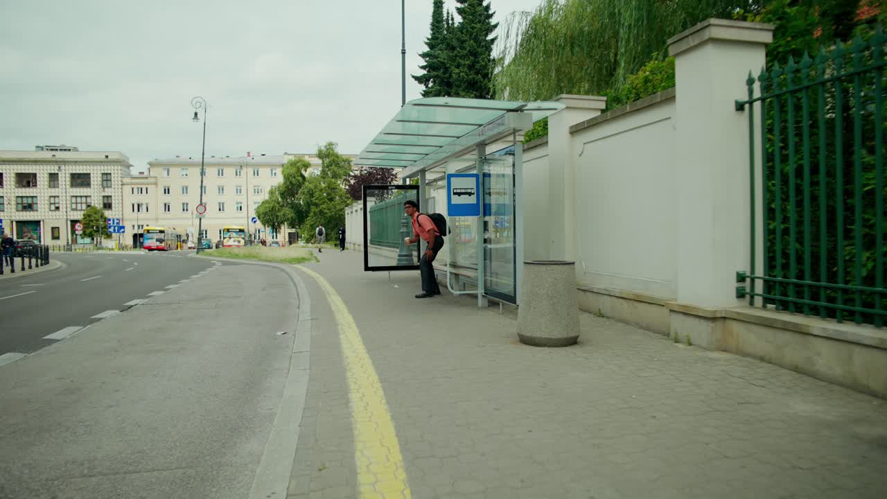 A person at a bus stop on a city street