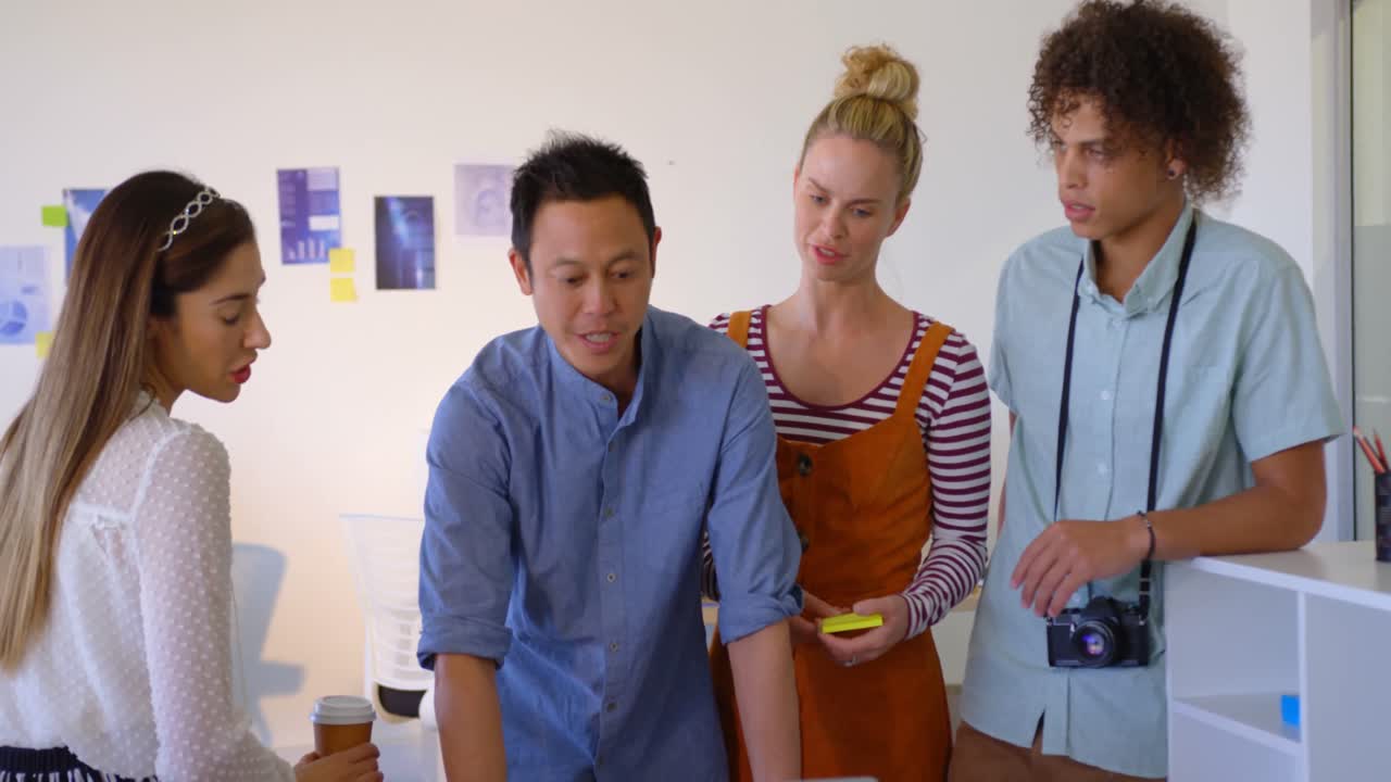 jóvenes empresarios de raza mixta mirando e interactuando entre sí en una computadora portátil 4k