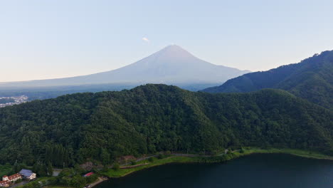 aerial: car driving on a lakeside road, mt fuji in background, summer in japan