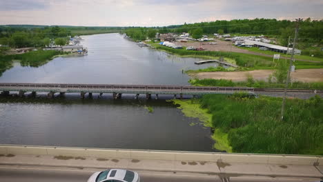 Drone-flying-over-a-bridge-in-a-beautiful-riverside-town