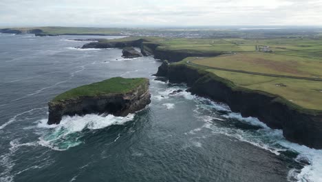 Vista-Aérea-De-Drones-Sobre-Las-Olas-Rompiendo-A-Lo-Largo-De-Los-Acantilados-De-Kilkee,-Condado-De-Clare-En-Irlanda