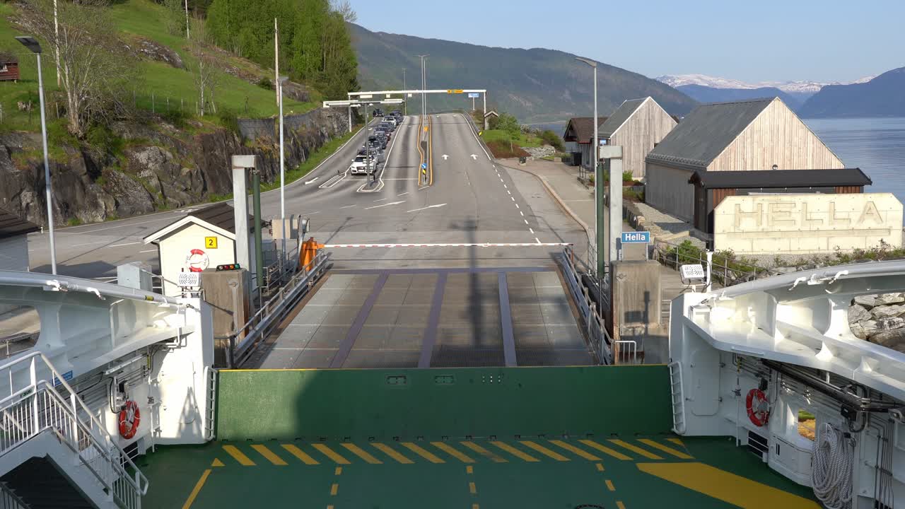 Ferry departing Hella ferry pier in sognefjord Norway - First person view from onboard the ferry and looking towards road and cars left behind