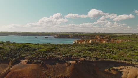 acantilados rocosos verdes aéreos de 4k en la costa con bahía azul