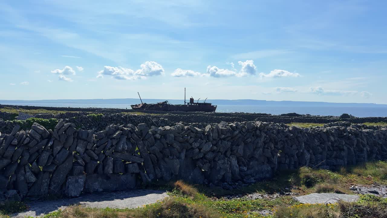 Inisheer Aran Island view of ship wreck over loose stonewall on a summer day Ireland epic Locations