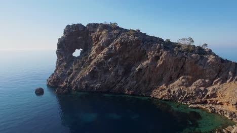 Aerial-view-in-4k-of-the-famous-rock-formation-Sa-Foradada-in-Mallorca---Westcost-Serra-de-Tramuntana---Balearic-Islands-in-Spain---Tourist-sightseeing-spot