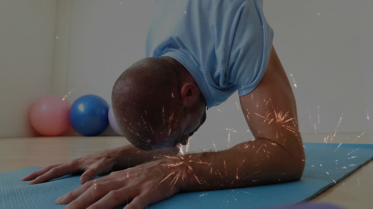 Man holding forearm plank on blue mat, starting by lowering head while spark overlay aiding fitness