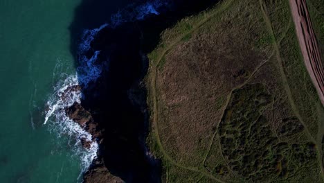 cornwall coastline cliffs from an aerial top down view with green turquoise waters along the coastline, england, uk