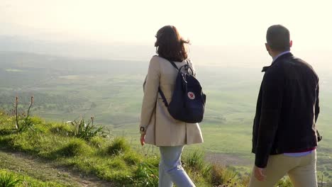 slow motion shot of couple walking near cliff edge enjoying rural view