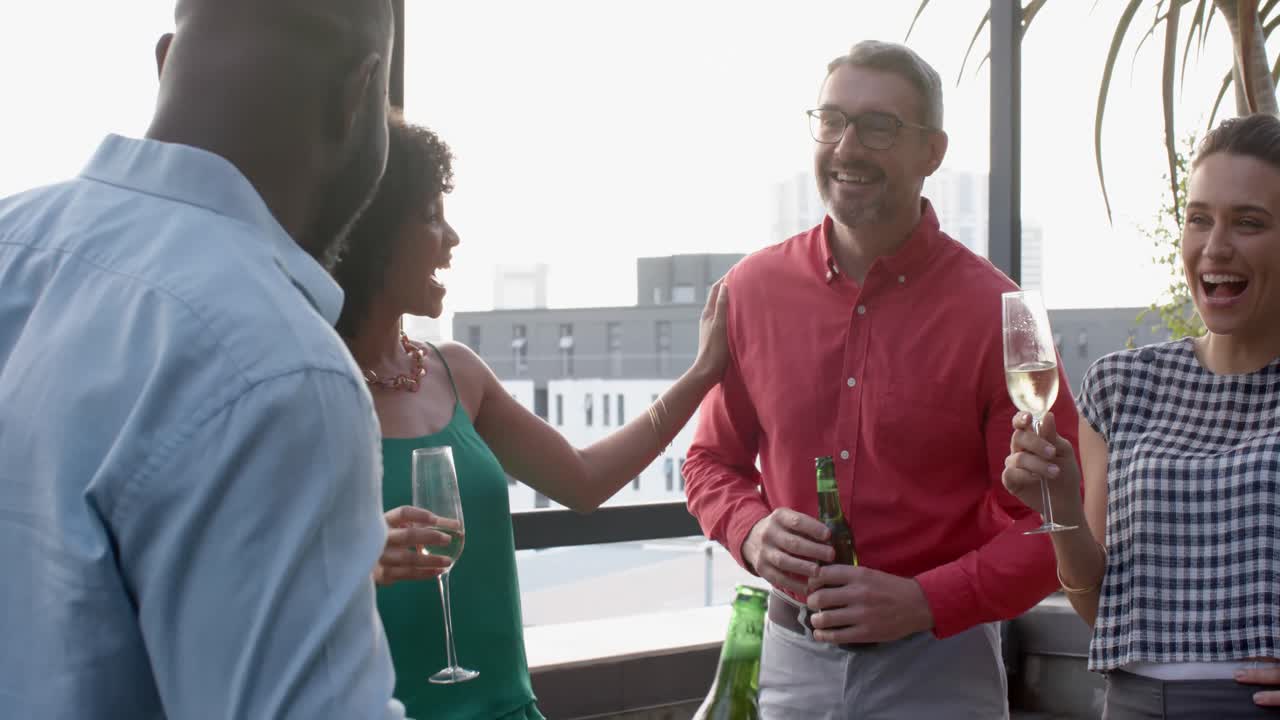 Divers team van blije collega's dat drankjes drinkt en met elkaar praat op het balkon van kantoor