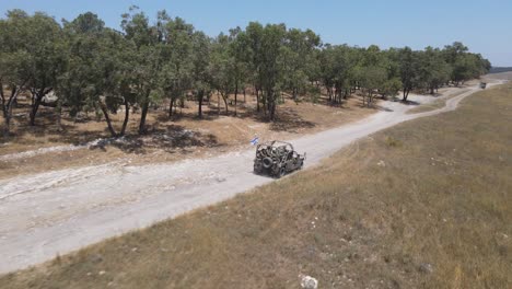 以色列軍隊中隊士兵乘坐 humvee 車輛穿過訓練地,在鄉村公路上行駛,空中追蹤槍擊