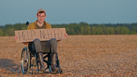 man in wheelchair asking for help in a field