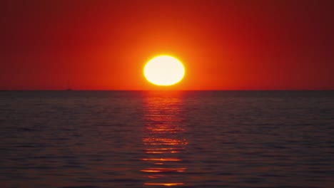 cinemagraph bucle de video sin problemas de una puesta de sol roja vibrante en una remota playa de arena costera de la toscana natural en italia con un cielo dramático y vistas panorámicas al mar. agua azul y turquesa en el pintoresco lugar de vacaciones turísticas de la naturaleza.