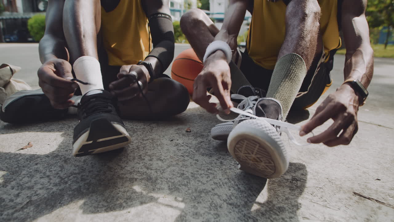 Athletes Sitting on Playground and Tying Shoelaces