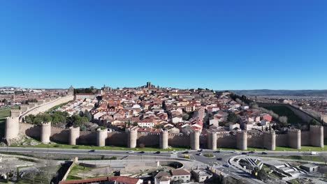 Ascending-flight-with-a-drone-in-the-medieval-UNESCO-world-heritage-city-of-Avila,-discovering-its-internal-dwellings-and-with-the-cathedral-in-the-background-that-is-part-of-the-wall-on-day-Spain