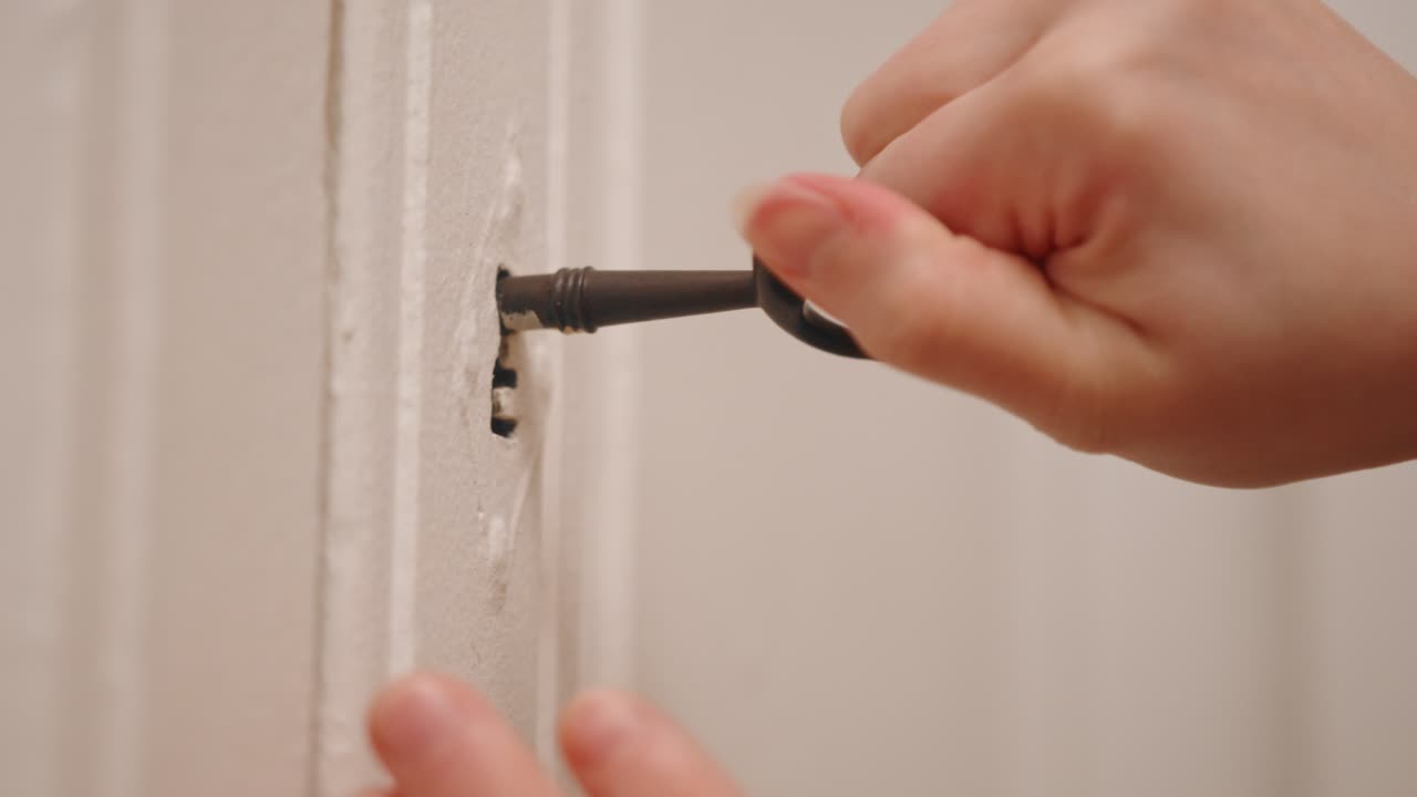Person hand use old vintage key to open wardrobe, close up view