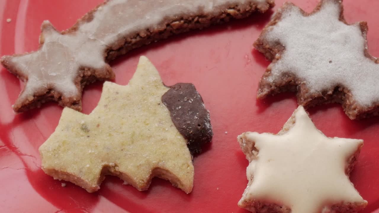 A bottom-to-top pan showcasing Christmas-themed German Butterplätzchen, featuring tree, star, and shooting star shapes, capturing festive charm and detail