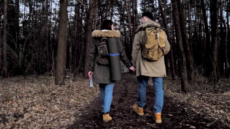 Caucasian couple hiking through the forest.