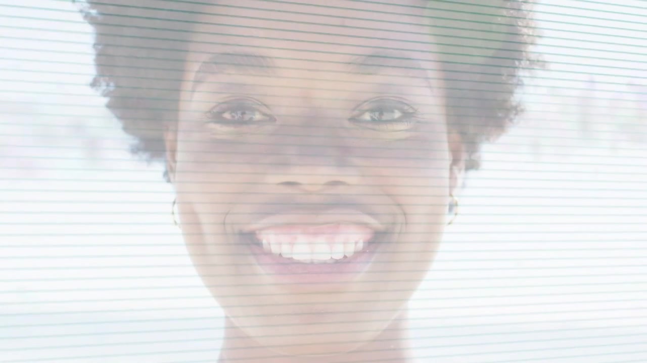 Vertical video: Recording woman opening eyes and smiling in backlit closeup in light top and hoops
