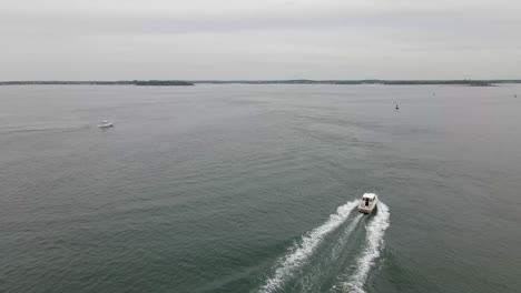 drones aéreos pasan volando por un pequeño barco pesquero que se dirige hacia tierra lejana