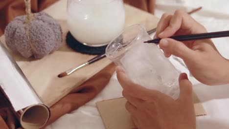 hands making markings on a cut plastic bottle for a creative diy recycling craft project