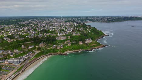 forward drone movement at the trestrignel beach at the coastal settlement with sweeping seafront and houses, perros-guirec, brittany, france.
