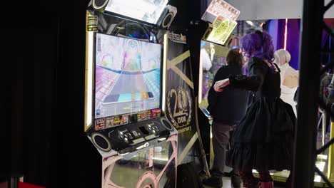 girl with purple hair and black dress costume cosplayer dancing on a electronic gaming machine revolution having fun collecting points at a convention event at lgx luxembourg