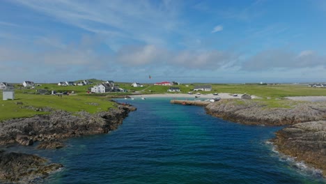 A-kitesurfer-in-a-small-harbour-on-the-Isle-of-Tiree,-aerial-shot