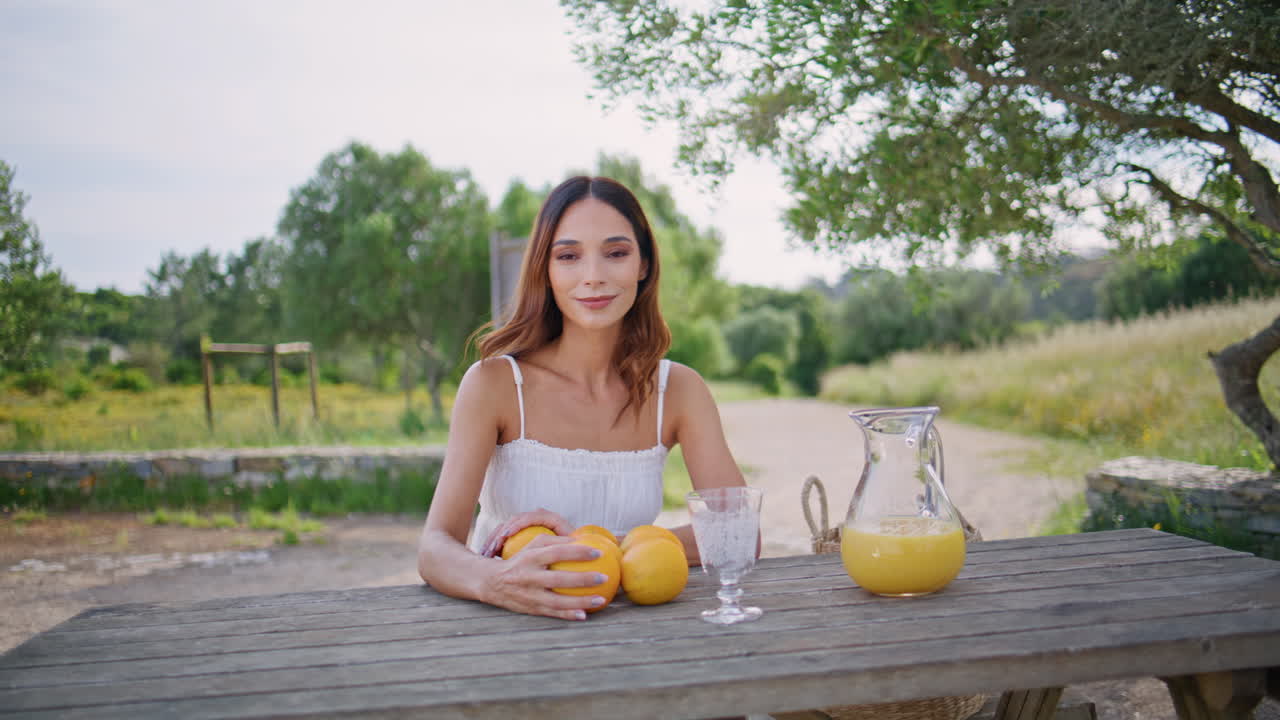 Resting model holding orange enjoying picnic at nature closeup. Lady with fruits