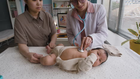 baby exam with doctor and mother present