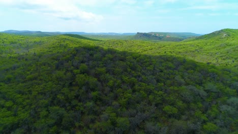 Aerial-panoramic-flyover-above-tropical-arid-mountains-half-covered-with-shadows