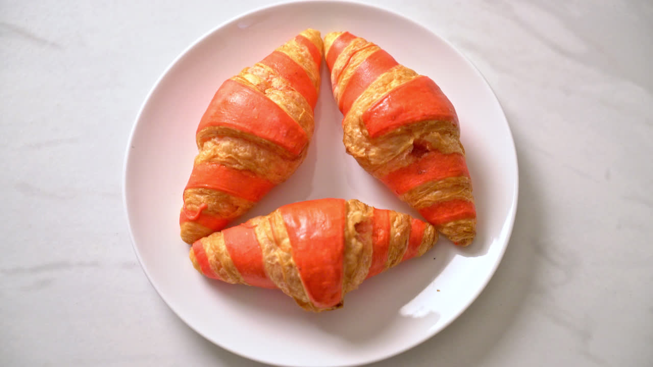 Croissant fresco con salsa de mermelada de fresa en la placa