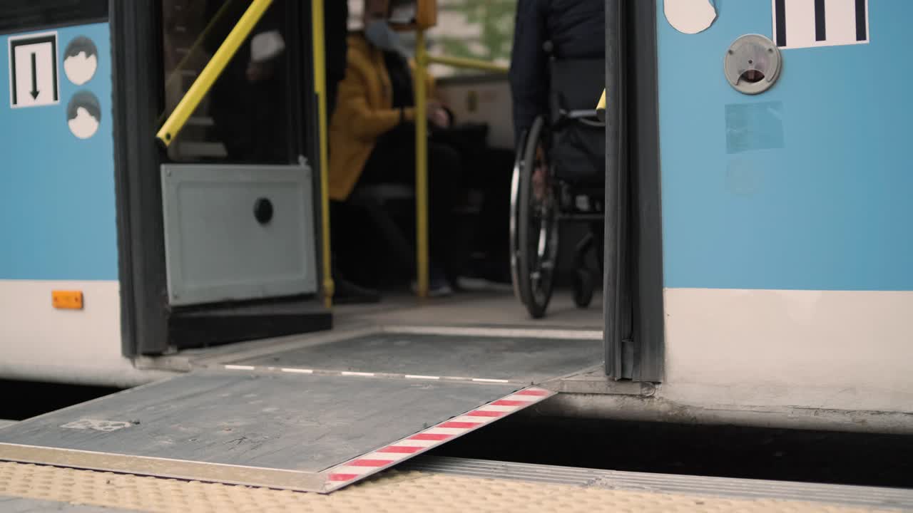 Person with a physical disability enters public transport with an accessible ramp