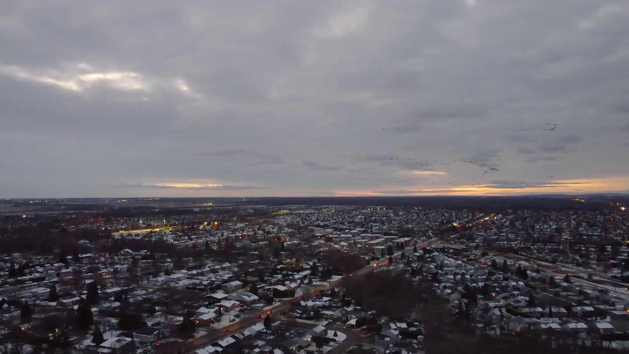 아름다운 분홍색 해가 지는 동안 몬트리올 남쪽의 세인트 콘스탄트 시 위를 날아다니는 새들의 항공 사진