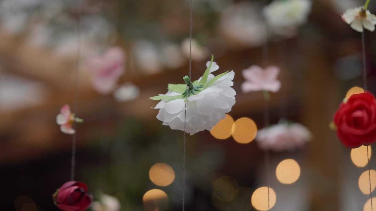 Floral decorations hanging from the ceiling. In the background, blurred lights create a cozy atmosphere