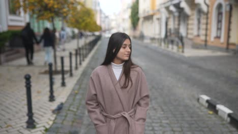 mujer caminando por una calle de la ciudad en otoño