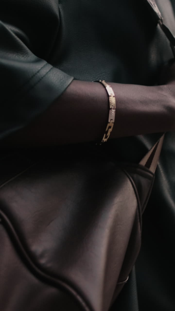 Close-up of a Person's Arm with Gold Bracelet Holding a Bag