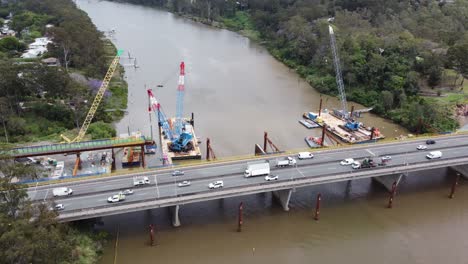drone flying towards a new bridge construction site over a river