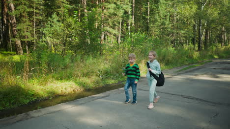 young siblings walking side by side on tarred road lined with tall green trees and grass, enjoying relaxed outdoor moment under daylight in calm countryside atmosphere near forest path