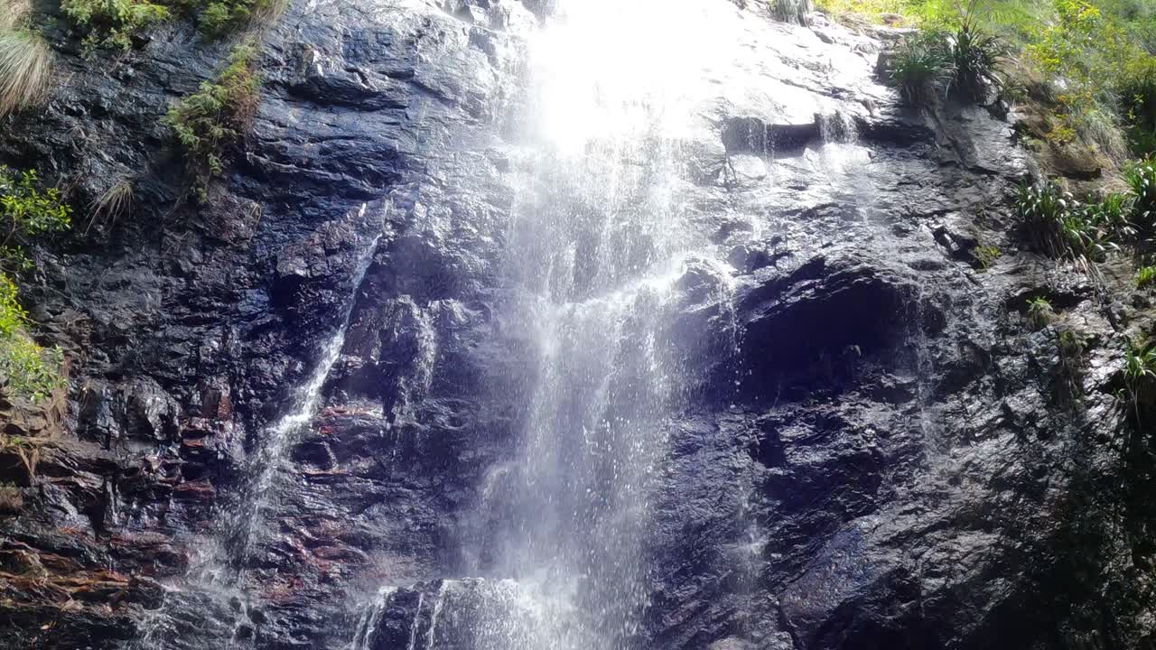 agua cayendo en cascada por un acantilado rocoso en una piscina