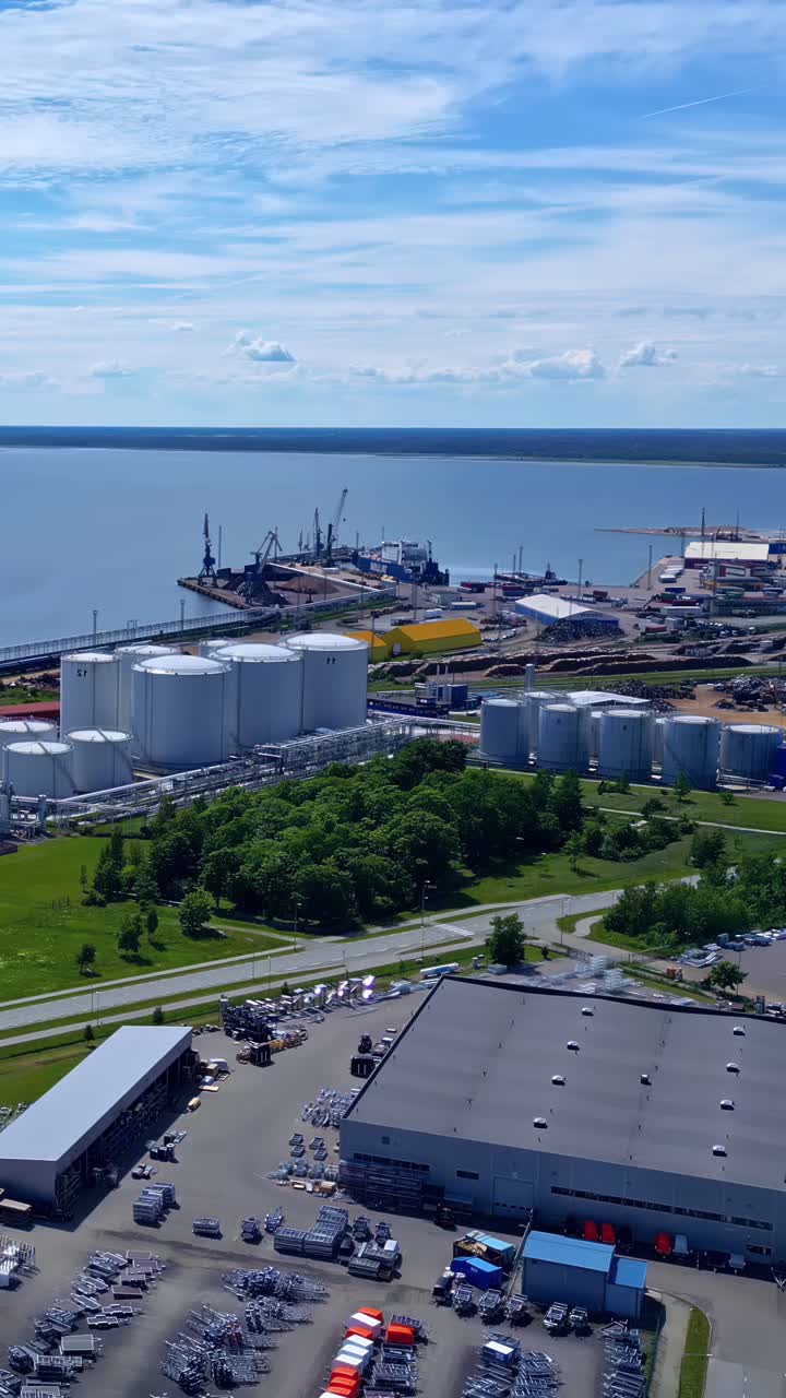 Aerial view of an industrial site and docks with cranes and storage. Vertical shot
