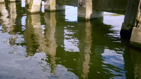 Pilotes-De-Muelle-De-Madera-En-El-Río-Ij-En-Amsterdam,-Países-Bajos