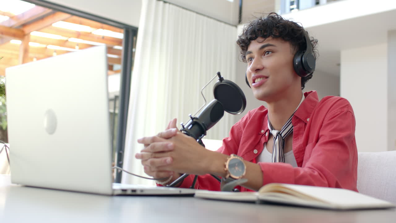 Recording podcast, teenage boy with headphones and microphone speaking at home office