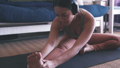 a woman wearing headphones while practicing yoga